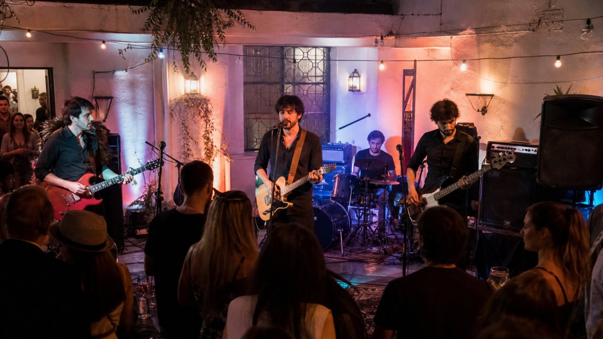Banda en vivo tocando en un evento social con escenario e iluminación